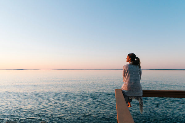 A woman enjoying her balanced lifestyle on a pier, experiencing the positive wellness effects of CBD  