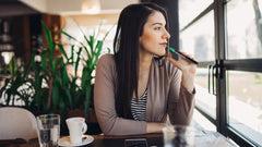 Women looking out the window while using a vape pen with Amphora Inspire CBD vape cartridge