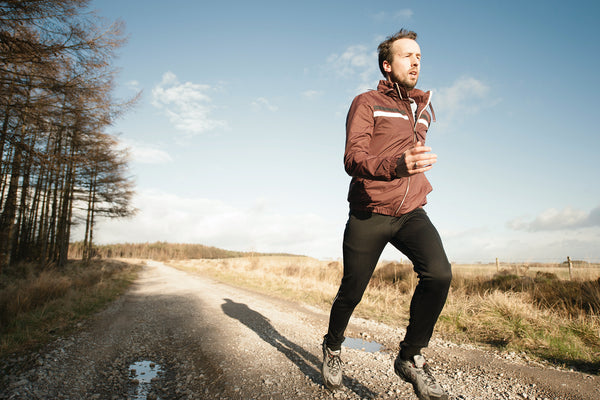 A man running on a trail during the light of day, promoting his fitness with CBD  