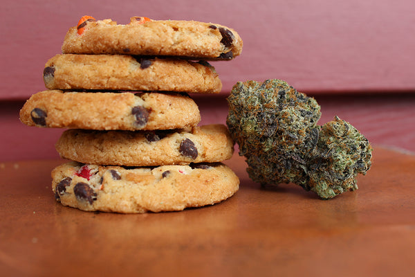 Cookies piled up next to CBD buds. CBD Oil vs CBD Edibles  