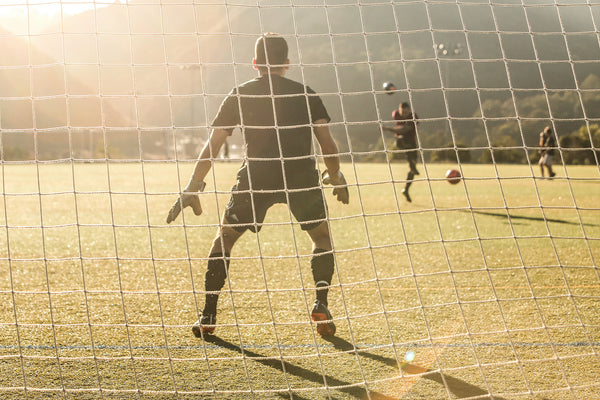 A game of soccer. The goalkeeper anticipating a shot from a striker. CBD and sports  