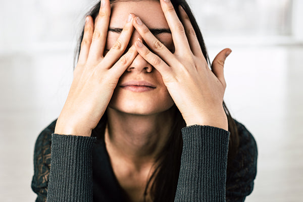 Women with hands over face considering Amphora Peace CBD for stress and anxiety