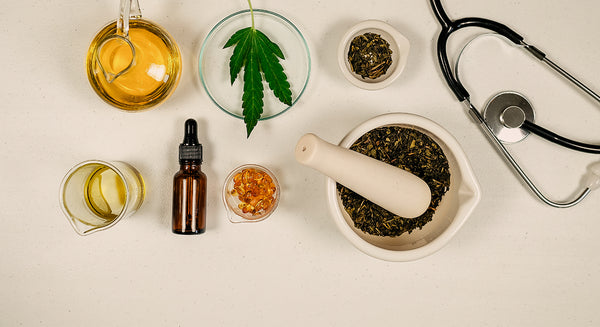 An array of CBD wellness products. CBD Oil, CBD Herbs, Hemp mixtures, and a stethoscope  