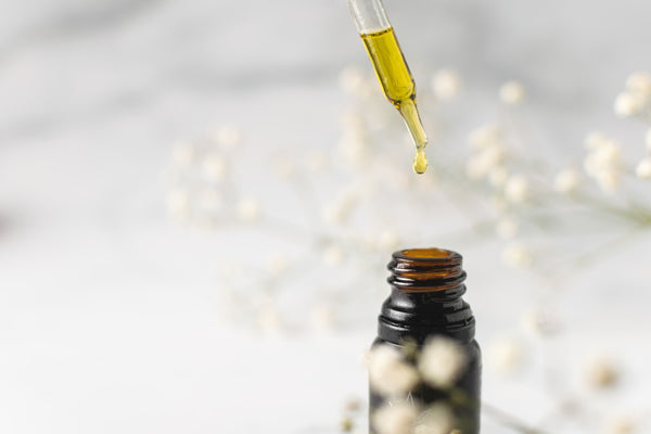 Amphora high strength CBD oil drops with a dropper of oil above on a white background with decor